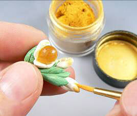 white clay being painted with yellow colorant
